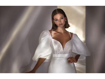 nueva-luxury-dream-cMujer con un vestido de novia con mangas abullonadas luciendo un peinado de novia sencilloapsule-collection
