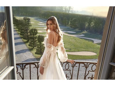 Mujer con un vestido de novia en el balcón junto a un jardín en una boda romántica