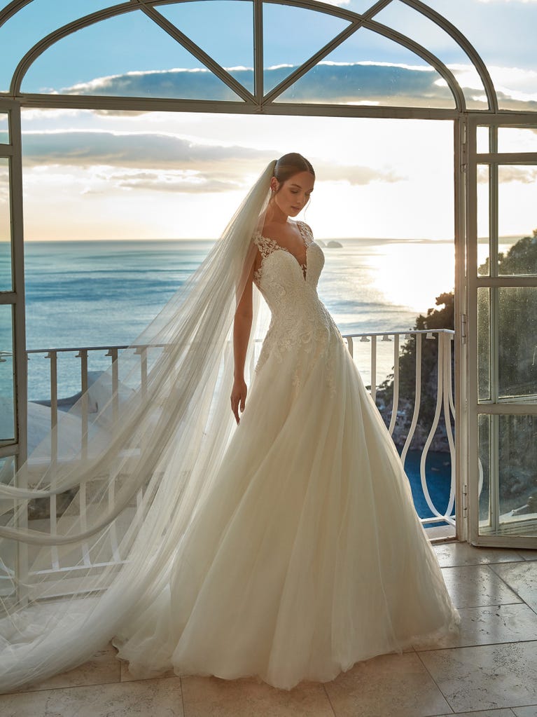 Tulle wedding dress with sleeveless bodice and sweetheart neckline. The embroidered lace creates a fabulous 3D effect, and the removable sleeves will look perfect during the ceremony.
