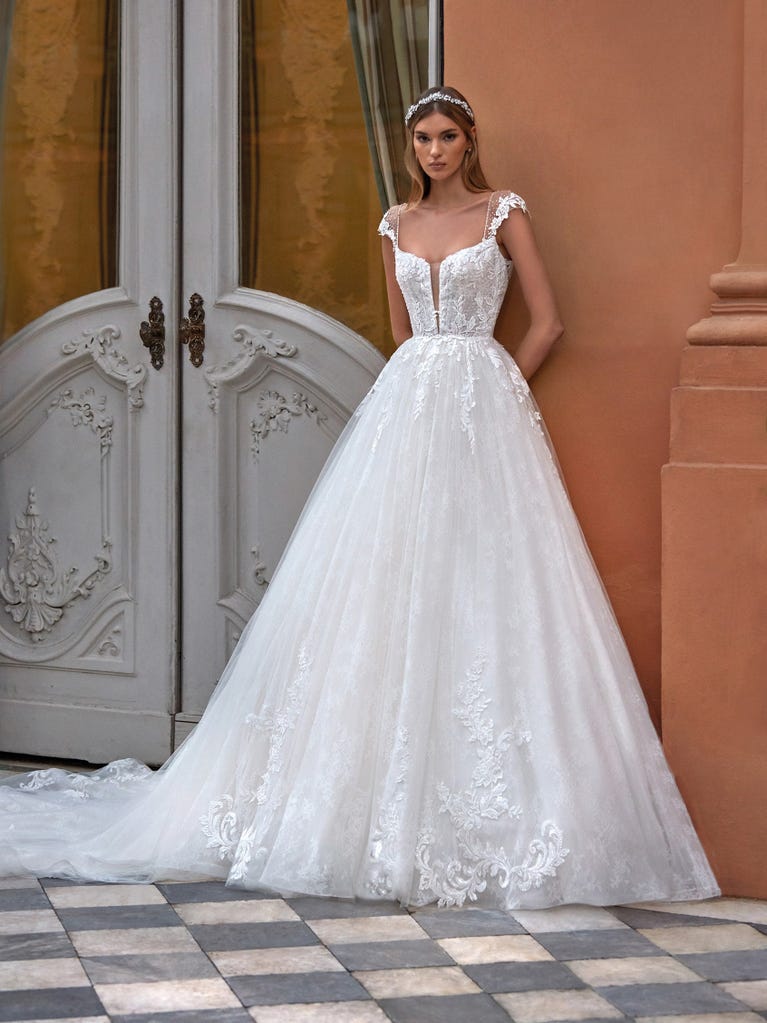 Tulle wedding dress with sleeveless bodice and sweetheart neckline. The embroidered lace creates a fabulous 3D effect, and the removable sleeves will look perfect during the ceremony.