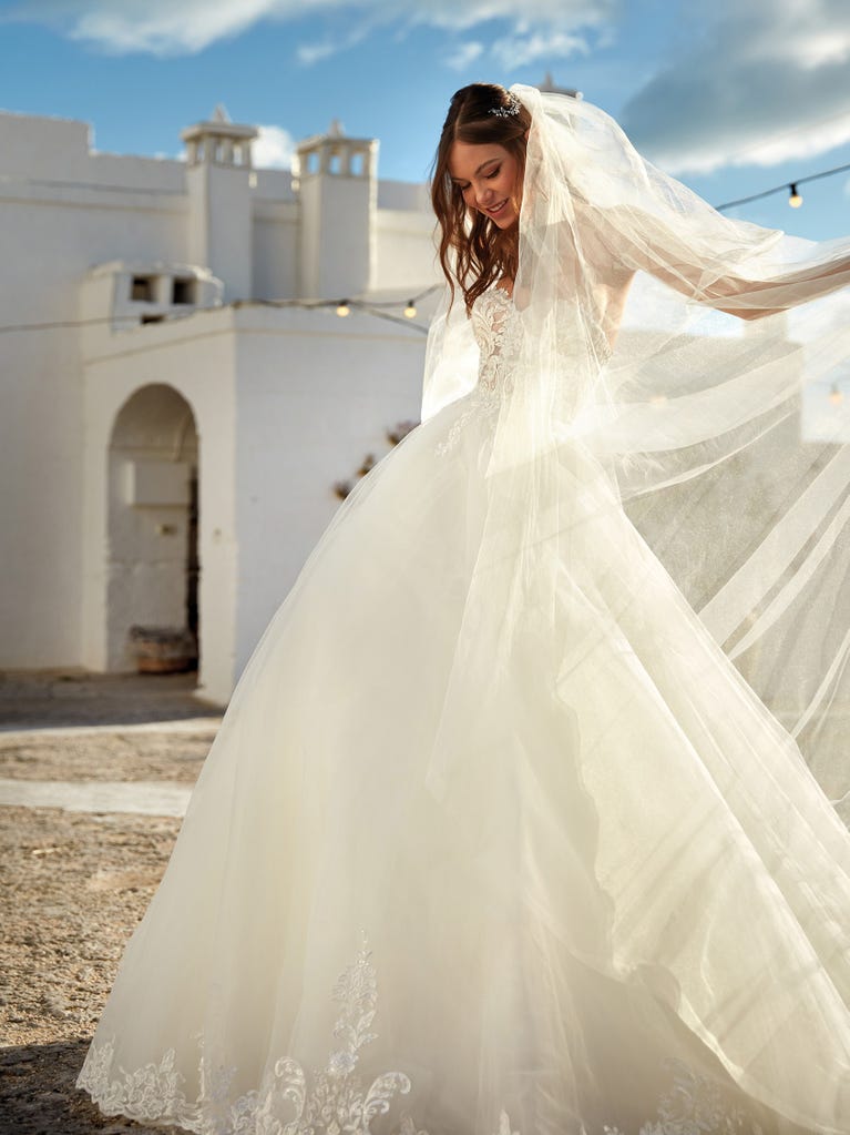 Tulle wedding dress with sleeveless bodice and sweetheart neckline. The embroidered lace creates a fabulous 3D effect, and the removable sleeves will look perfect during the ceremony.