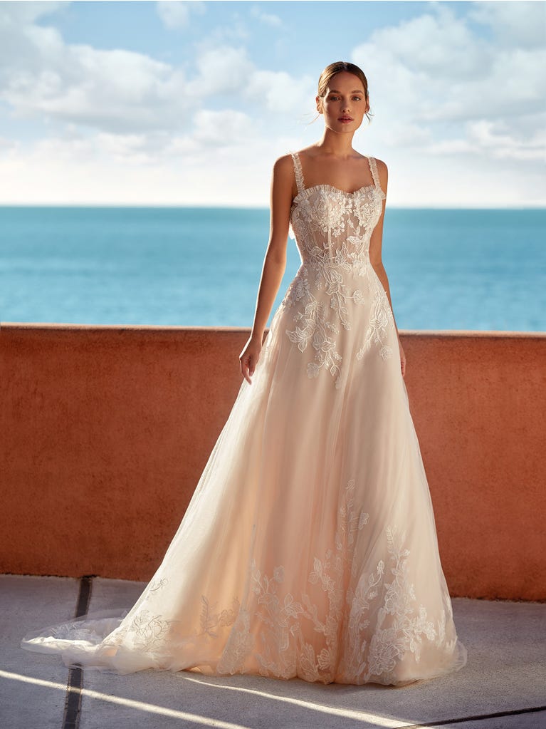 Tulle wedding dress with sleeveless bodice and sweetheart neckline. The embroidered lace creates a fabulous 3D effect, and the removable sleeves will look perfect during the ceremony.