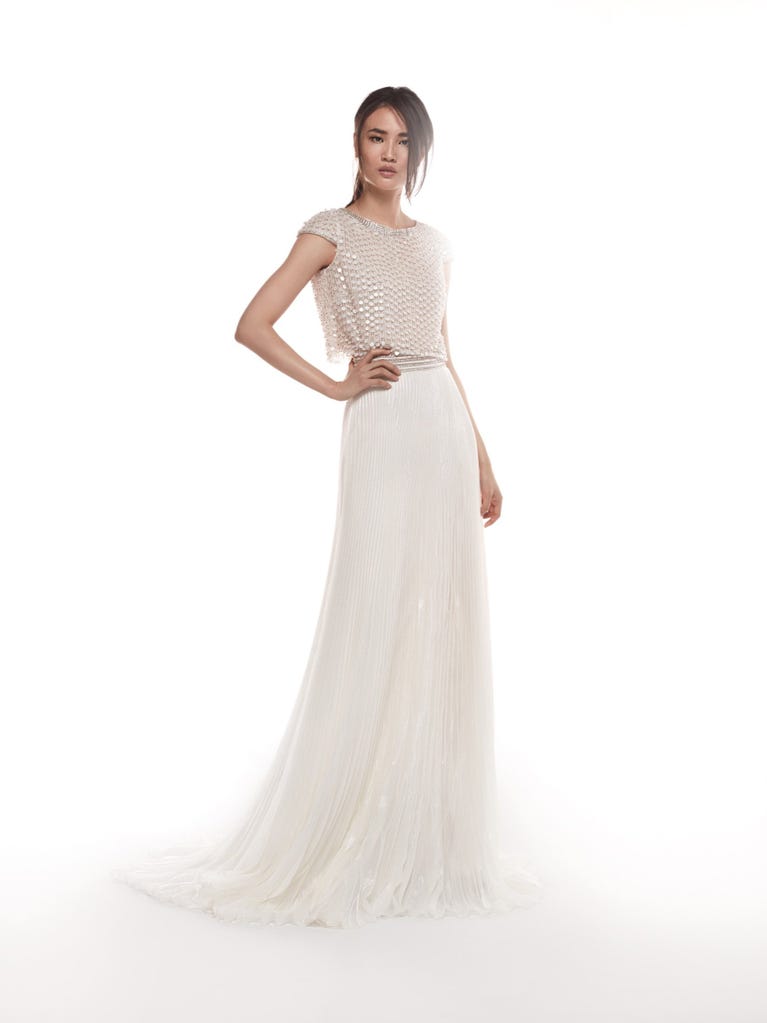 Romantic mermaid wedding dress of light pink Chantilly lace with plunging V-neck that continues on the sleeves. The keyhole opening in back and the tulle overskirt add romanticism to this dreamy dress.