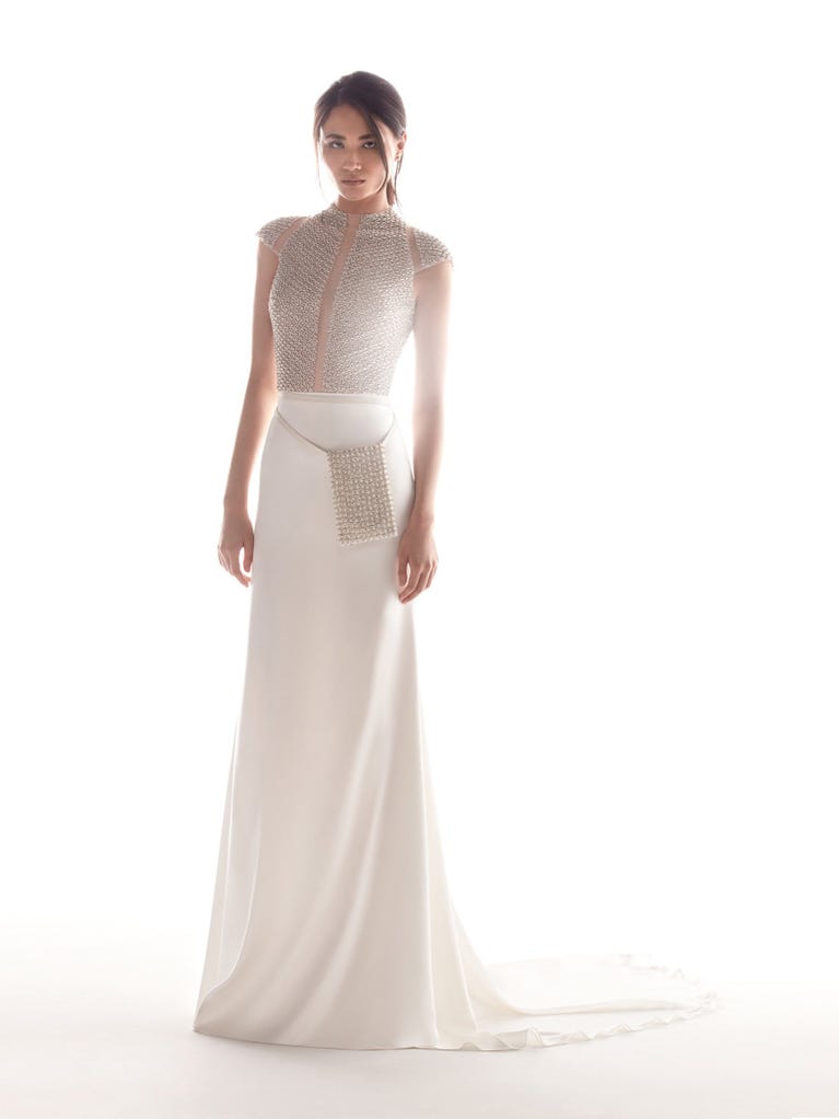 Romantic mermaid wedding dress of light pink Chantilly lace with plunging V-neck that continues on the sleeves. The keyhole opening in back and the tulle overskirt add romanticism to this dreamy dress.