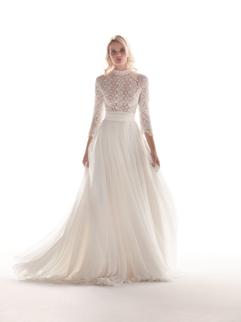 Romantic mermaid wedding dress of light pink Chantilly lace with plunging V-neck that continues on the sleeves. The keyhole opening in back and the tulle overskirt add romanticism to this dreamy dress.