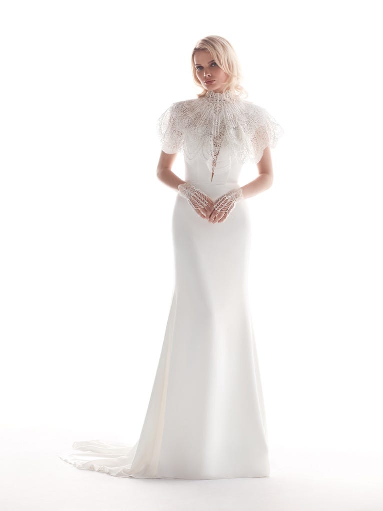 Romantic mermaid wedding dress of light pink Chantilly lace with plunging V-neck that continues on the sleeves. The keyhole opening in back and the tulle overskirt add romanticism to this dreamy dress.