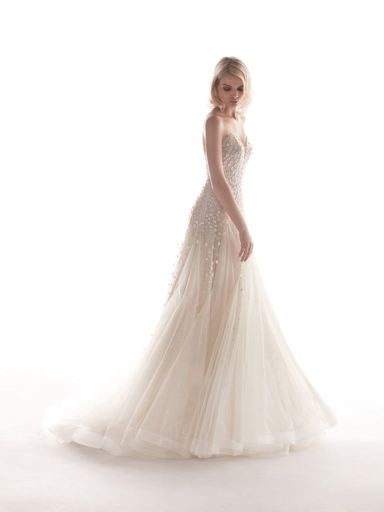 Romantic mermaid wedding dress of light pink Chantilly lace with plunging V-neck that continues on the sleeves. The keyhole opening in back and the tulle overskirt add romanticism to this dreamy dress.
