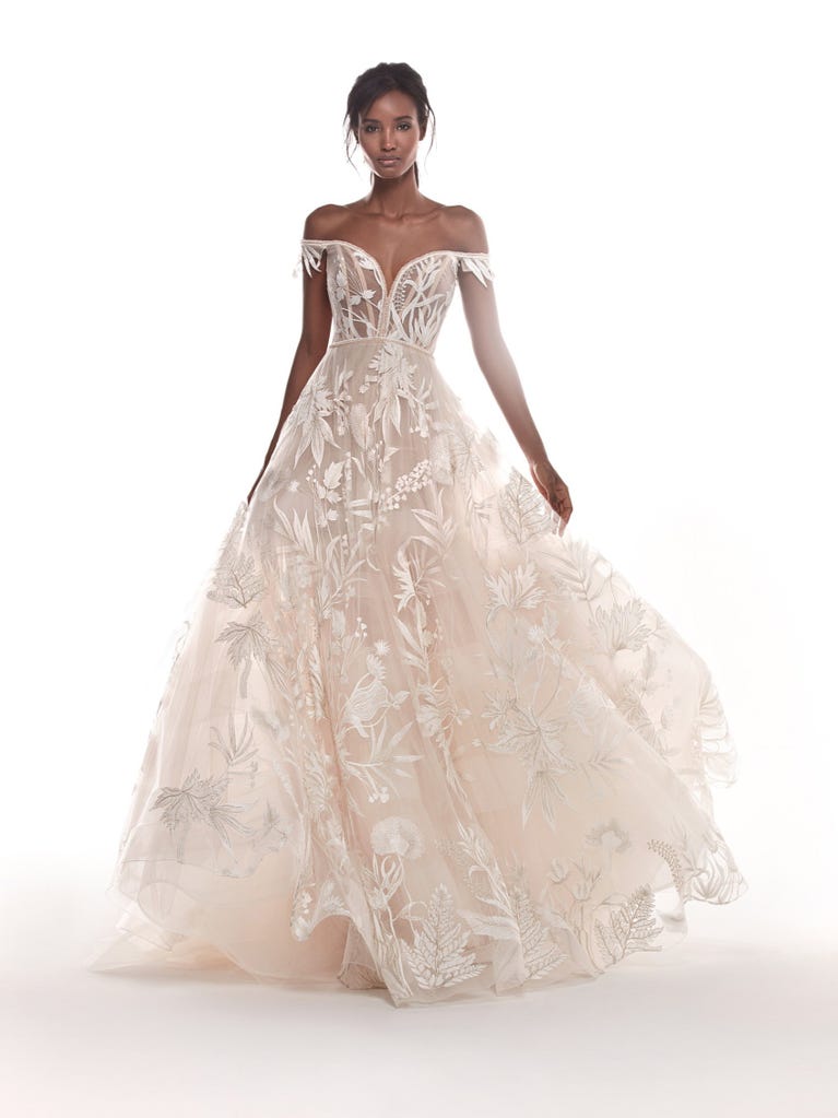 Romantic mermaid wedding dress of light pink Chantilly lace with plunging V-neck that continues on the sleeves. The keyhole opening in back and the tulle overskirt add romanticism to this dreamy dress.