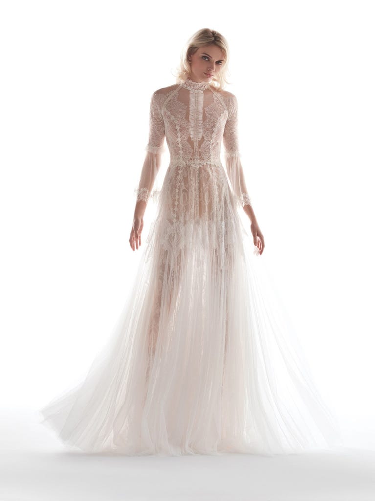 Romantic mermaid wedding dress of light pink Chantilly lace with plunging V-neck that continues on the sleeves. The keyhole opening in back and the tulle overskirt add romanticism to this dreamy dress.