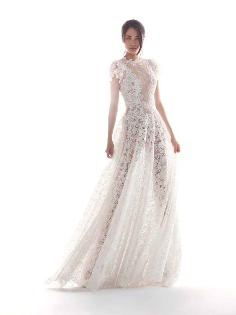 Romantic mermaid wedding dress of light pink Chantilly lace with plunging V-neck that continues on the sleeves. The keyhole opening in back and the tulle overskirt add romanticism to this dreamy dress.