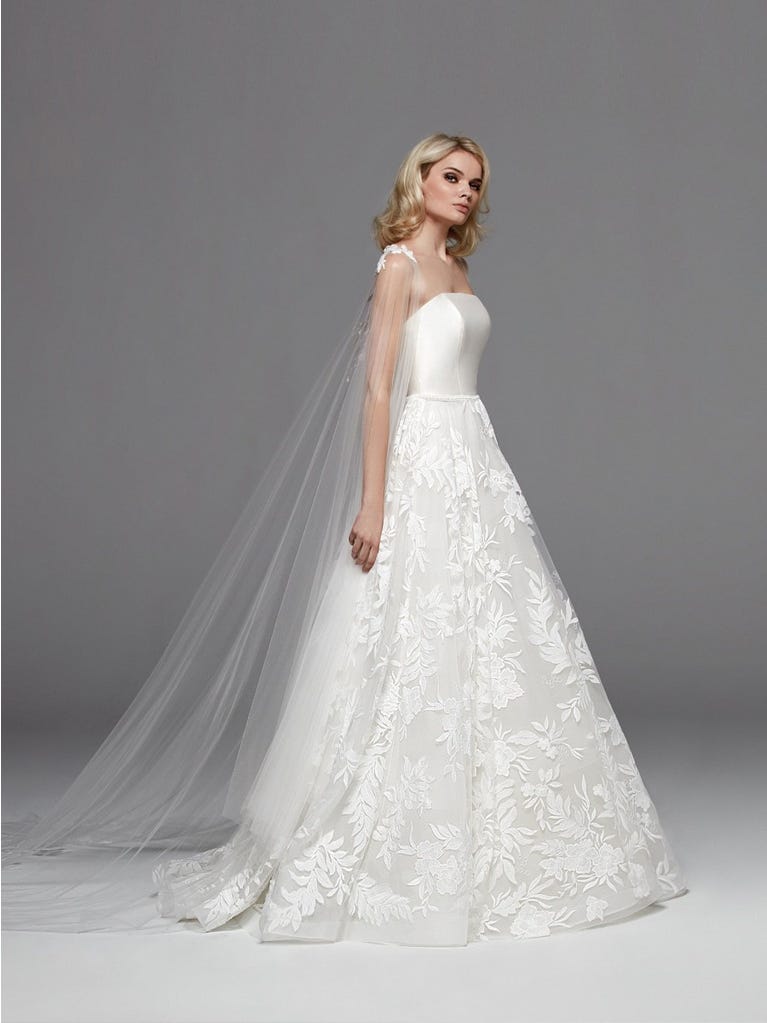 Romantic mermaid wedding dress of light pink Chantilly lace with plunging V-neck that continues on the sleeves. The keyhole opening in back and the tulle overskirt add romanticism to this dreamy dress.