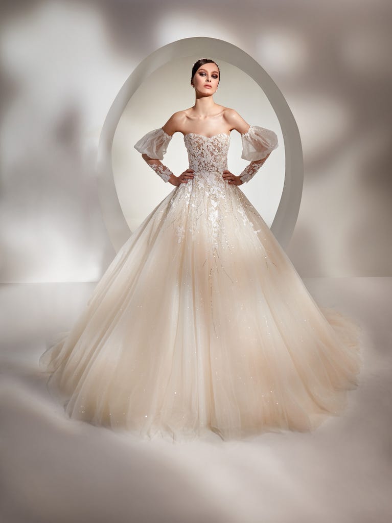 Tulle wedding dress with sleeveless bodice and sweetheart neckline. The embroidered lace creates a fabulous 3D effect, and the removable sleeves will look perfect during the ceremony.