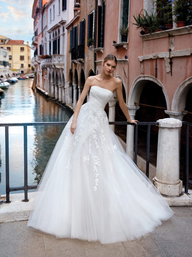 Tulle wedding dress with sleeveless bodice and sweetheart neckline. The embroidered lace creates a fabulous 3D effect, and the removable sleeves will look perfect during the ceremony.