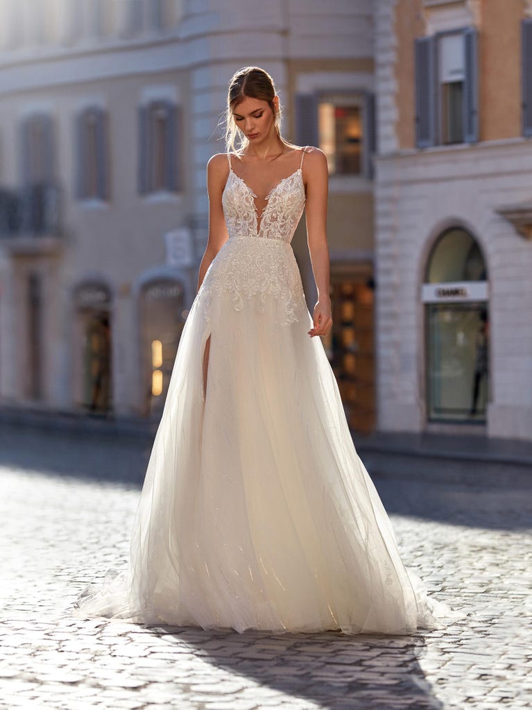Flared wedding dress with voluminous yet lightweight tulle skirt with lace embroidered with floral motifs. For brides who dream of a romantic, feminine dress to say “I do.”