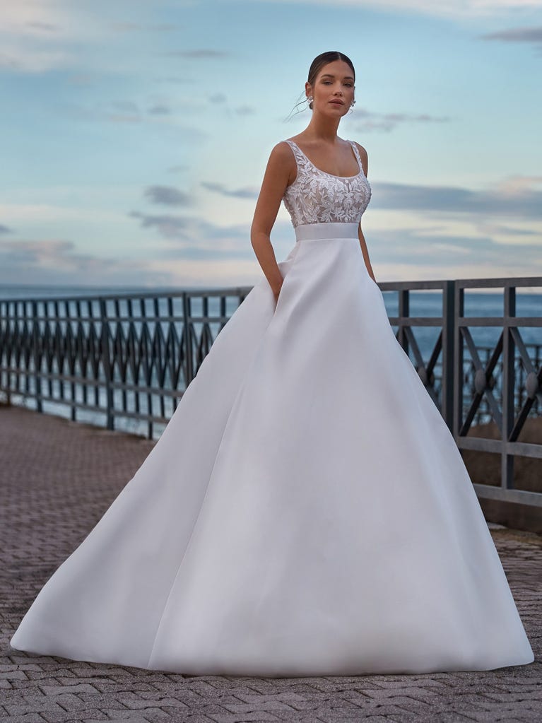 Tulle wedding dress with sleeveless bodice and sweetheart neckline. The embroidered lace creates a fabulous 3D effect, and the removable sleeves will look perfect during the ceremony.