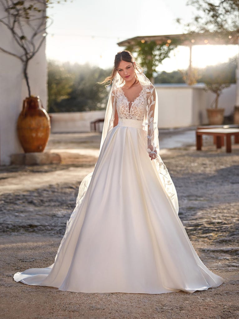 Tulle wedding dress with sleeveless bodice and sweetheart neckline. The embroidered lace creates a fabulous 3D effect, and the removable sleeves will look perfect during the ceremony.