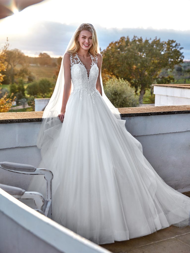 Tulle wedding dress with sleeveless bodice and sweetheart neckline. The embroidered lace creates a fabulous 3D effect, and the removable sleeves will look perfect during the ceremony.