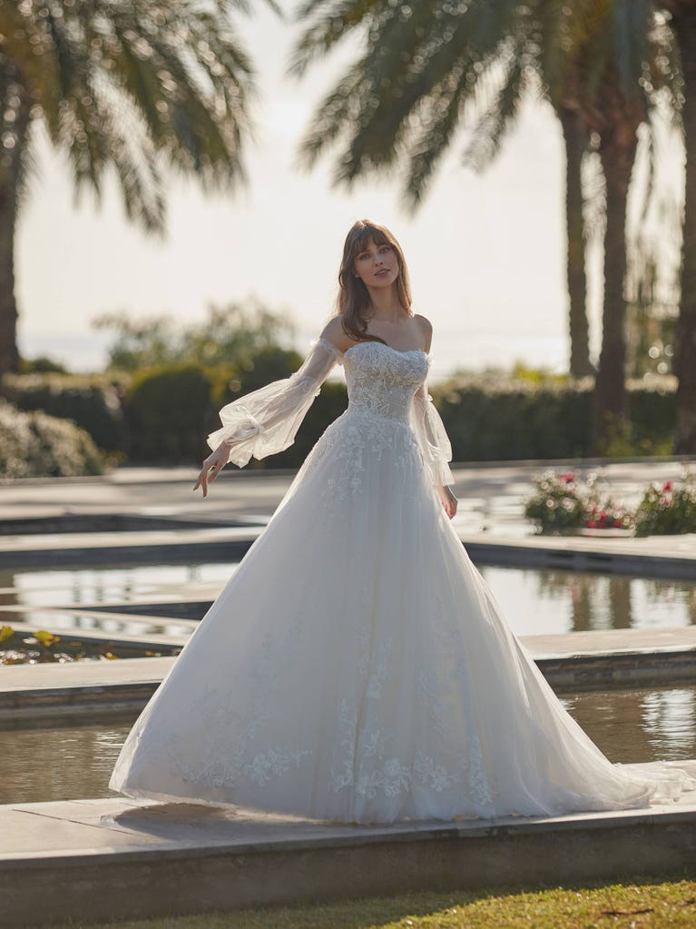 Tulle wedding dress with sleeveless bodice and sweetheart neckline. The embroidered lace creates a fabulous 3D effect, and the removable sleeves will look perfect during the ceremony.