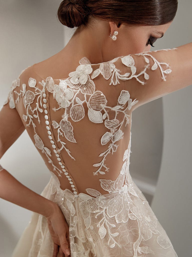 Flared wedding dress with voluminous yet lightweight tulle skirt with lace embroidered with floral motifs. For brides who dream of a romantic, feminine dress to say “I do.”