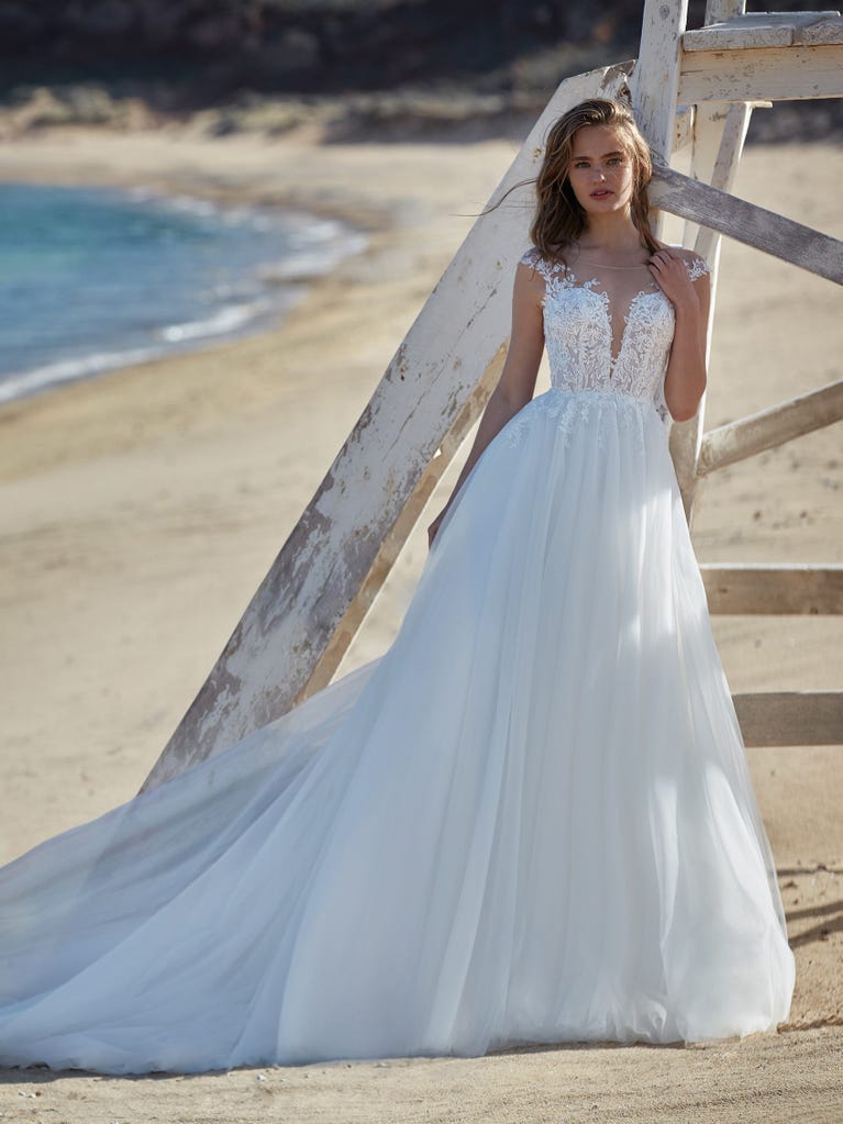 Tulle wedding dress with sleeveless bodice and sweetheart neckline. The embroidered lace creates a fabulous 3D effect, and the removable sleeves will look perfect during the ceremony.