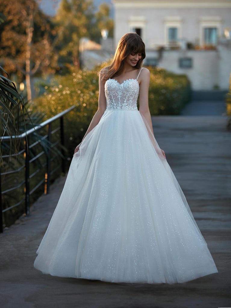 Tulle wedding dress with sleeveless bodice and sweetheart neckline. The embroidered lace creates a fabulous 3D effect, and the removable sleeves will look perfect during the ceremony.