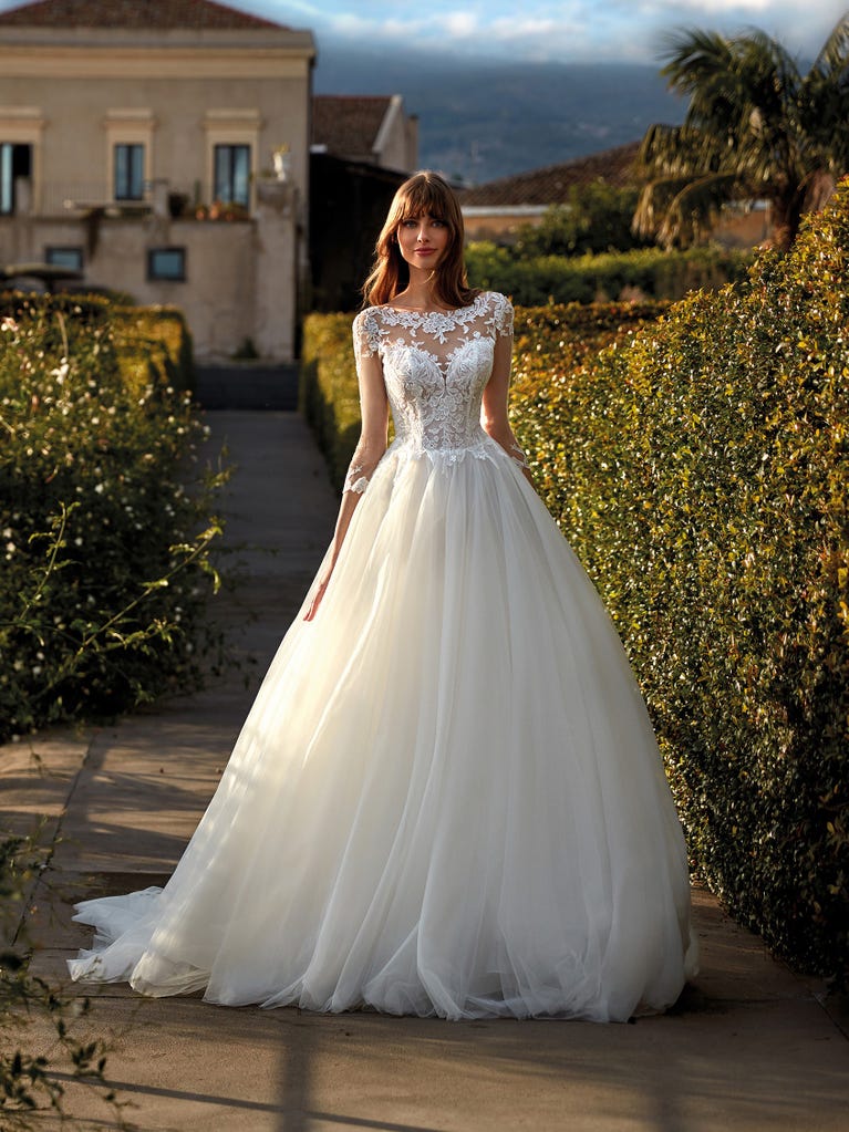 Tulle wedding dress with sleeveless bodice and sweetheart neckline. The embroidered lace creates a fabulous 3D effect, and the removable sleeves will look perfect during the ceremony.