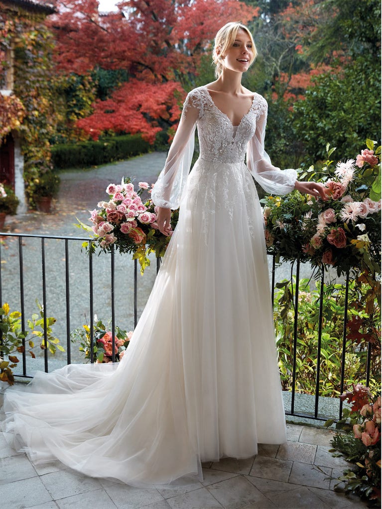 Mermaid dress of embroidered champagne tulle with plunging V-neck in front and back and short sleeves. The tulle overskirt adds volume and romanticism.