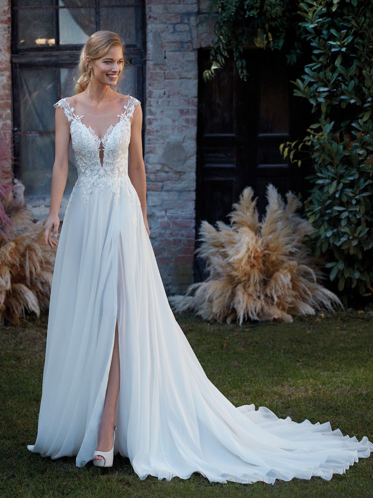 Mermaid dress of embroidered champagne tulle with plunging V-neck in front and back and short sleeves. The tulle overskirt adds volume and romanticism.