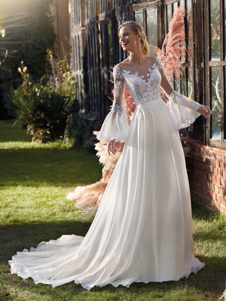 Mermaid dress of embroidered champagne tulle with plunging V-neck in front and back and short sleeves. The tulle overskirt adds volume and romanticism.