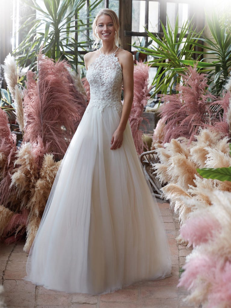 Mermaid dress of embroidered champagne tulle with plunging V-neck in front and back and short sleeves. The tulle overskirt adds volume and romanticism.