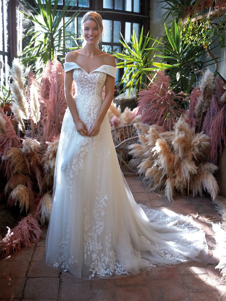 Mermaid dress of embroidered champagne tulle with plunging V-neck in front and back and short sleeves. The tulle overskirt adds volume and romanticism.