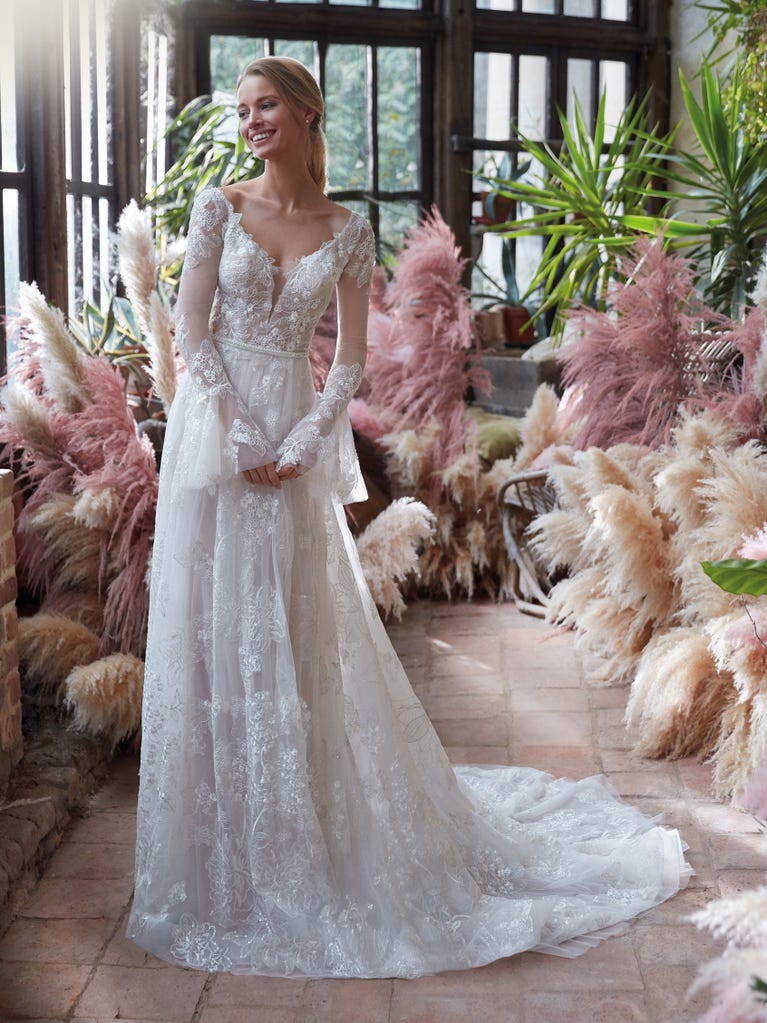 Mermaid dress of embroidered champagne tulle with plunging V-neck in front and back and short sleeves. The tulle overskirt adds volume and romanticism.