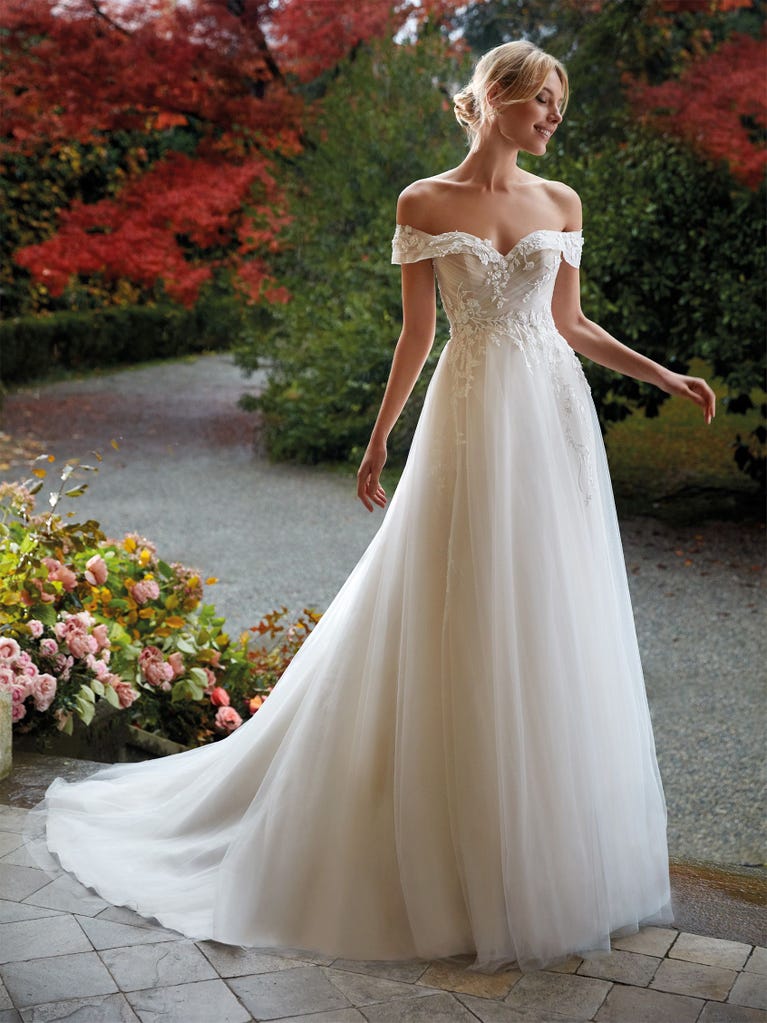 Mermaid dress of embroidered champagne tulle with plunging V-neck in front and back and short sleeves. The tulle overskirt adds volume and romanticism.