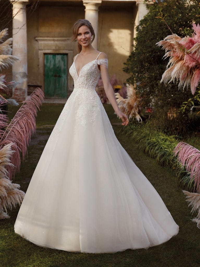 Tulle wedding dress with sleeveless bodice and sweetheart neckline. The embroidered lace creates a fabulous 3D effect, and the removable sleeves will look perfect during the ceremony.