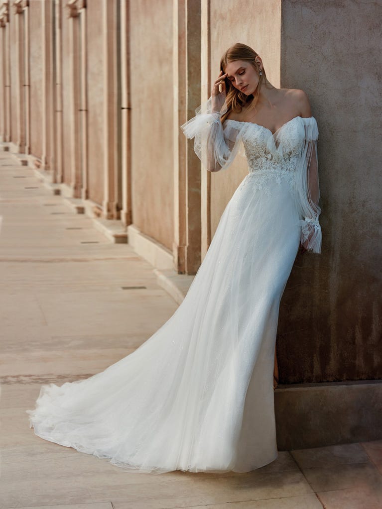 Flared wedding dress with voluminous yet lightweight tulle skirt with lace embroidered with floral motifs. For brides who dream of a romantic, feminine dress to say “I do.”