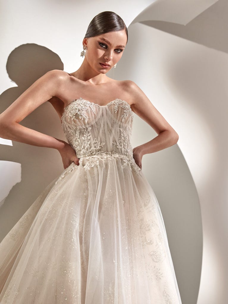 Tulle wedding dress with sleeveless bodice and sweetheart neckline. The embroidered lace creates a fabulous 3D effect, and the removable sleeves will look perfect during the ceremony.