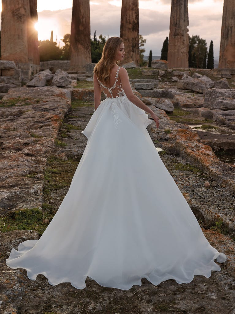 Princess wedding dress in carmine red tulle. The tulle ruffles create a light volume on the skirt and the sleeveless bodice, while the high waistline enhances the waist.