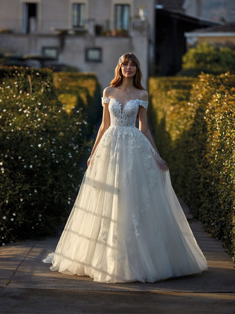 Tulle wedding dress with sleeveless bodice and sweetheart neckline. The embroidered lace creates a fabulous 3D effect, and the removable sleeves will look perfect during the ceremony.