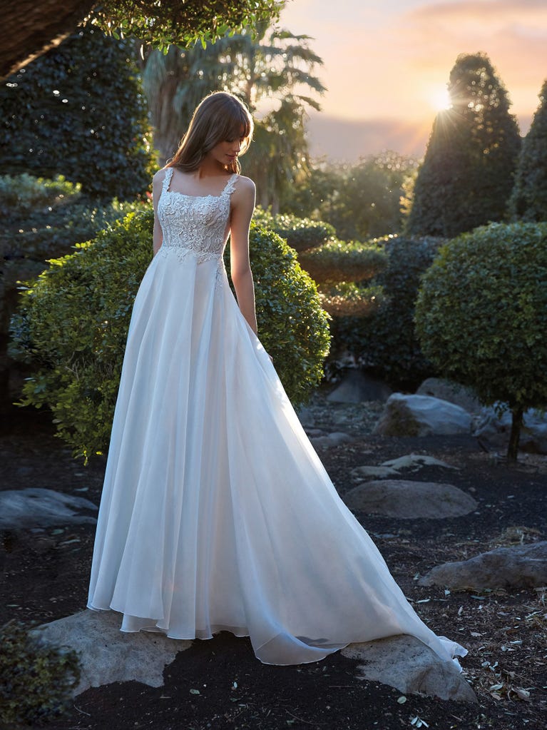 Flared wedding dress with voluminous yet lightweight tulle skirt with lace embroidered with floral motifs. For brides who dream of a romantic, feminine dress to say “I do.”