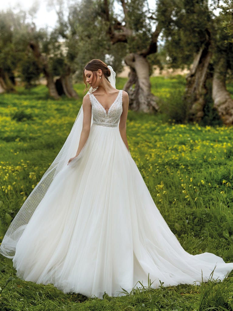 Tulle wedding dress with sleeveless bodice and sweetheart neckline. The embroidered lace creates a fabulous 3D effect, and the removable sleeves will look perfect during the ceremony.