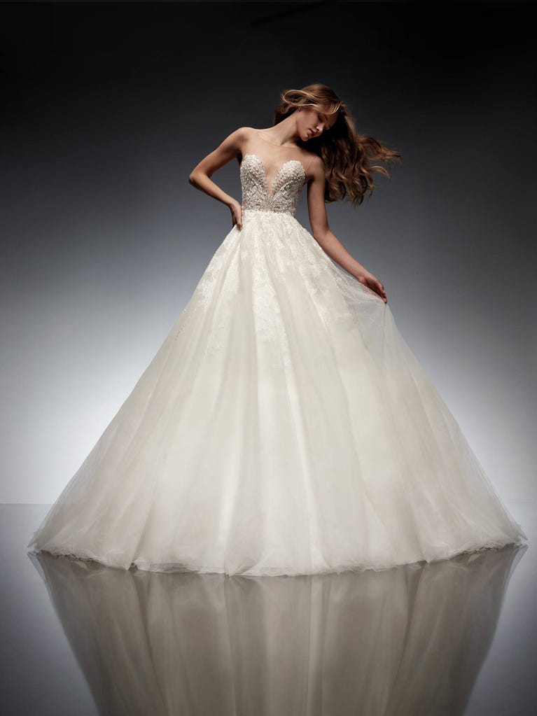 Tulle wedding dress with sleeveless bodice and sweetheart neckline. The embroidered lace creates a fabulous 3D effect, and the removable sleeves will look perfect during the ceremony.
