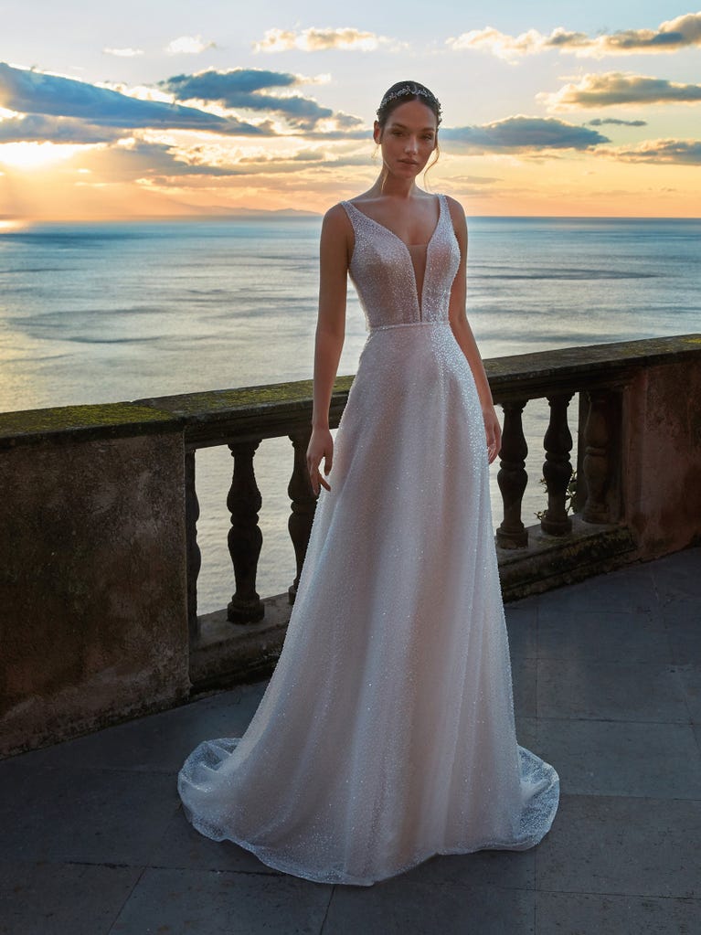 Flared wedding dress with voluminous yet lightweight tulle skirt with lace embroidered with floral motifs. For brides who dream of a romantic, feminine dress to say “I do.”