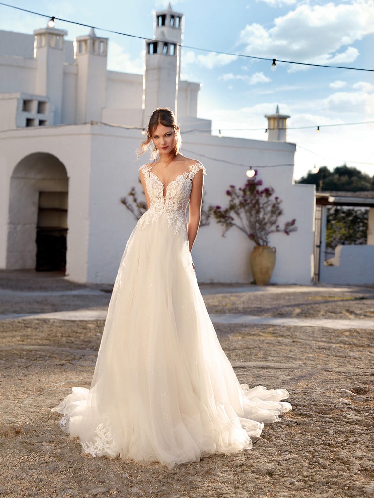 Flared wedding dress with voluminous yet lightweight tulle skirt with lace embroidered with floral motifs. For brides who dream of a romantic, feminine dress to say “I do.”