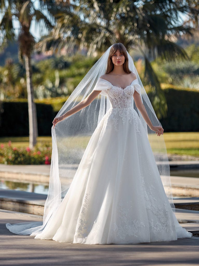 Tulle wedding dress with sleeveless bodice and sweetheart neckline. The embroidered lace creates a fabulous 3D effect, and the removable sleeves will look perfect during the ceremony.