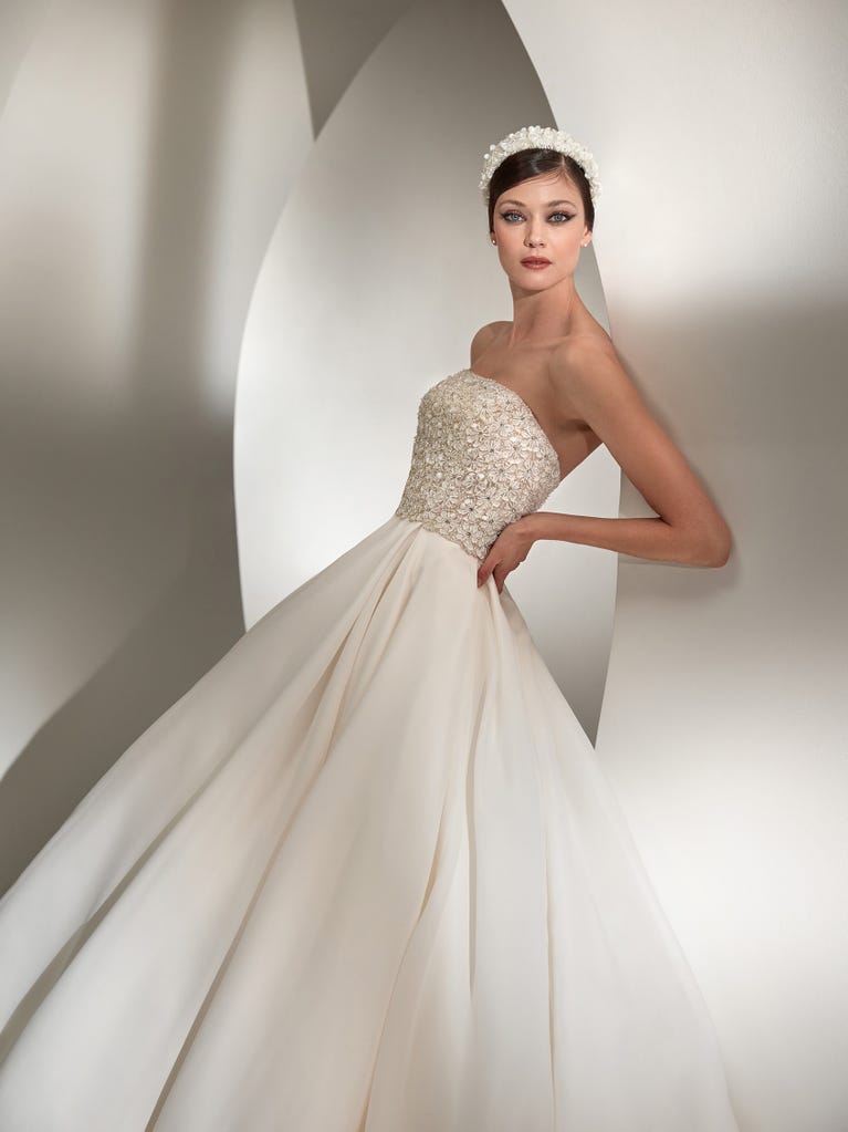 Tulle wedding dress with sleeveless bodice and sweetheart neckline. The embroidered lace creates a fabulous 3D effect, and the removable sleeves will look perfect during the ceremony.