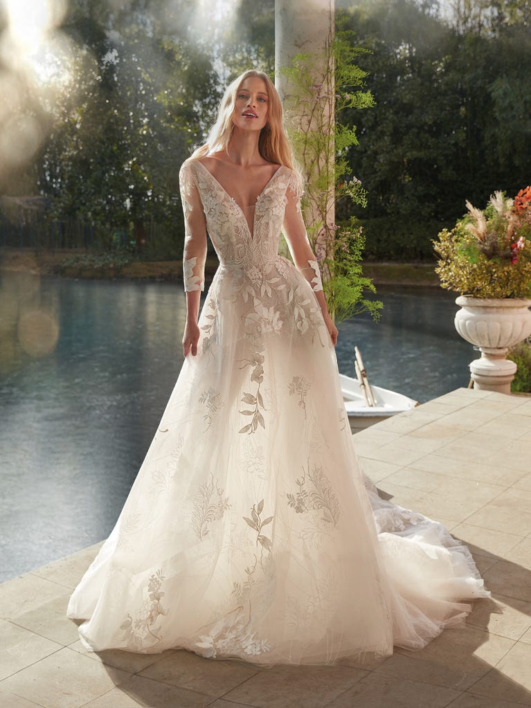 Tulle wedding dress with sleeveless bodice and sweetheart neckline. The embroidered lace creates a fabulous 3D effect, and the removable sleeves will look perfect during the ceremony.