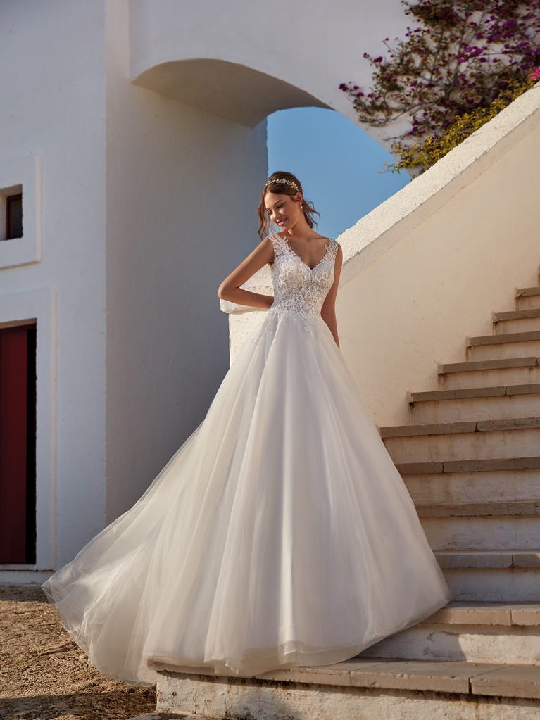 Tulle wedding dress with sleeveless bodice and sweetheart neckline. The embroidered lace creates a fabulous 3D effect, and the removable sleeves will look perfect during the ceremony.