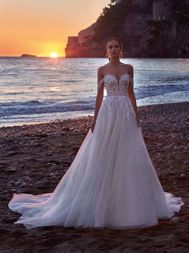 Tulle wedding dress with sleeveless bodice and sweetheart neckline. The embroidered lace creates a fabulous 3D effect, and the removable sleeves will look perfect during the ceremony.