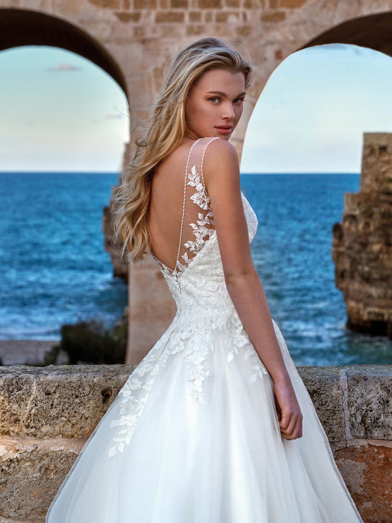 Tulle wedding dress with sleeveless bodice and sweetheart neckline. The embroidered lace creates a fabulous 3D effect, and the removable sleeves will look perfect during the ceremony.