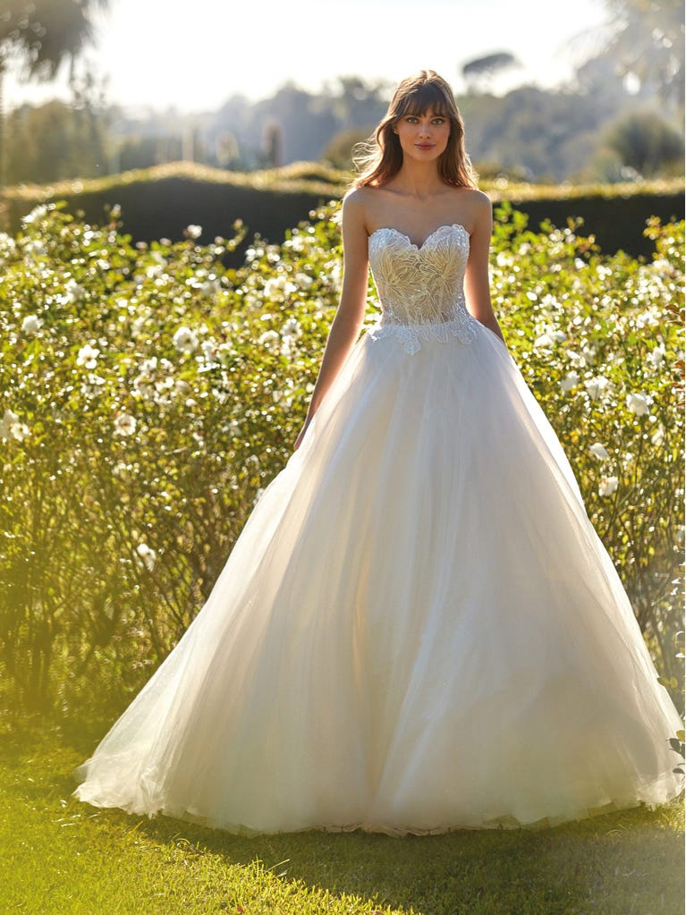 Tulle wedding dress with sleeveless bodice and sweetheart neckline. The embroidered lace creates a fabulous 3D effect, and the removable sleeves will look perfect during the ceremony.